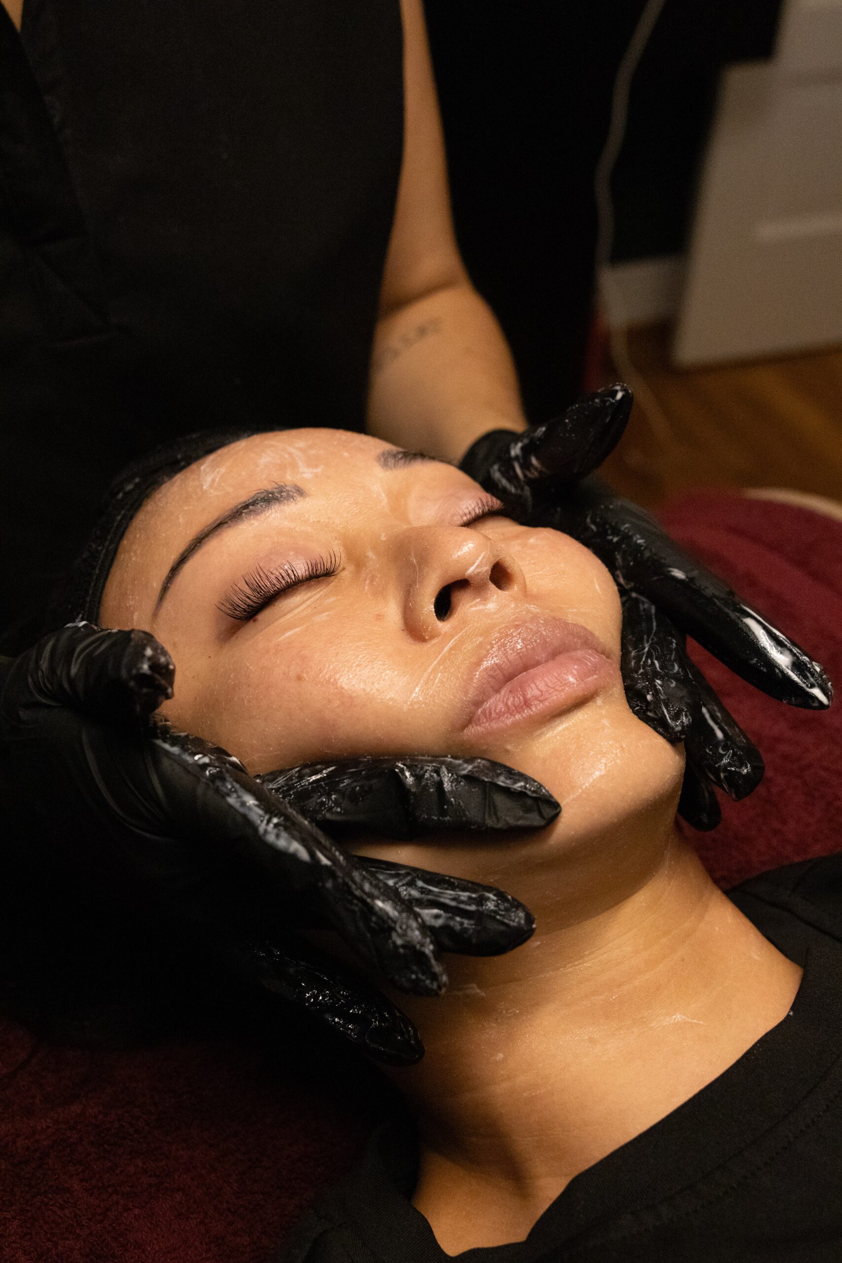 esthetician performing a calming facial treatment to help soothe and calm rosacea prone skin